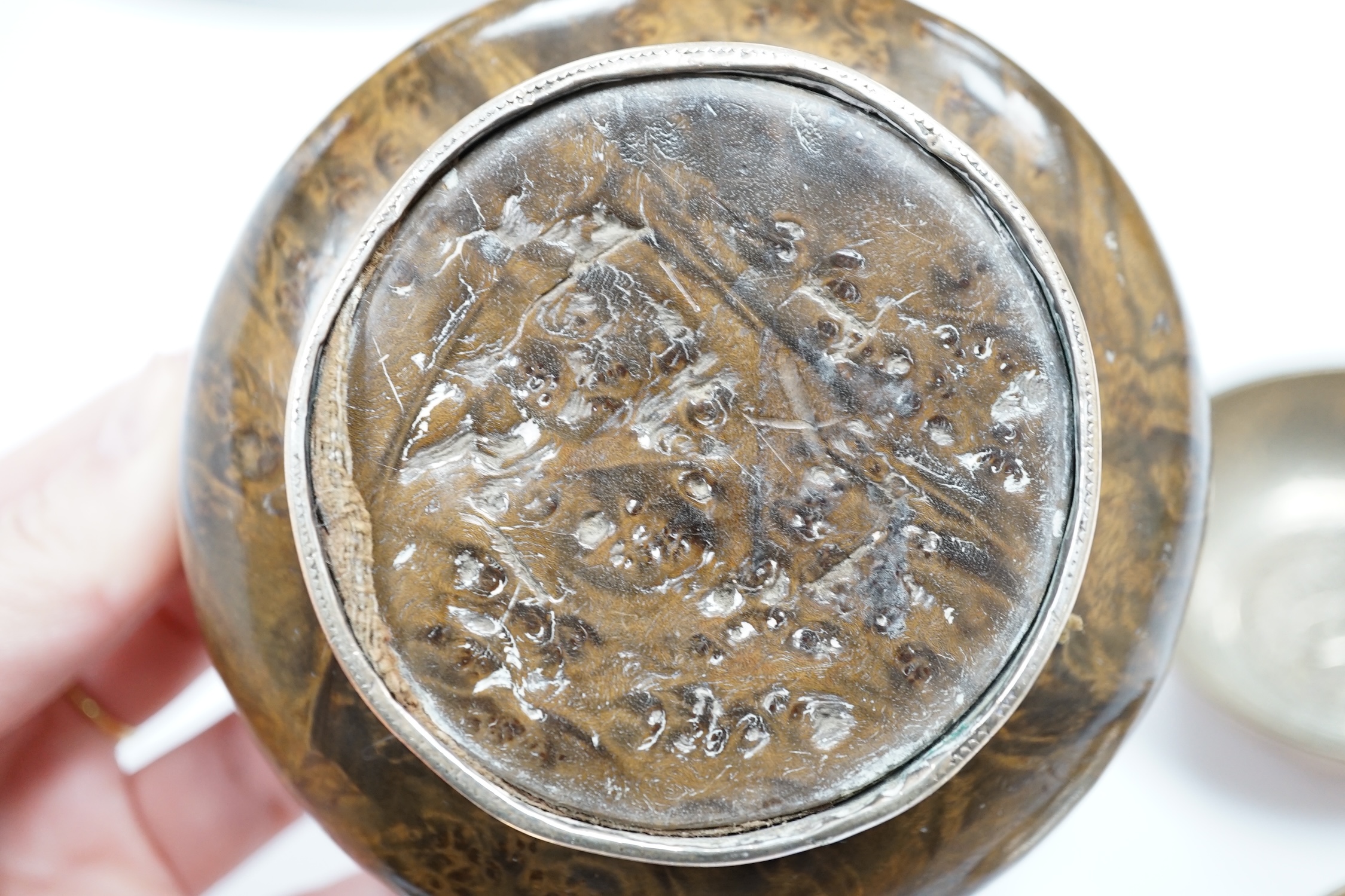 A Tibetan white metal mounted cup, two coin inset dishes and a silver matchbox holder, largest 11.5cm diameter